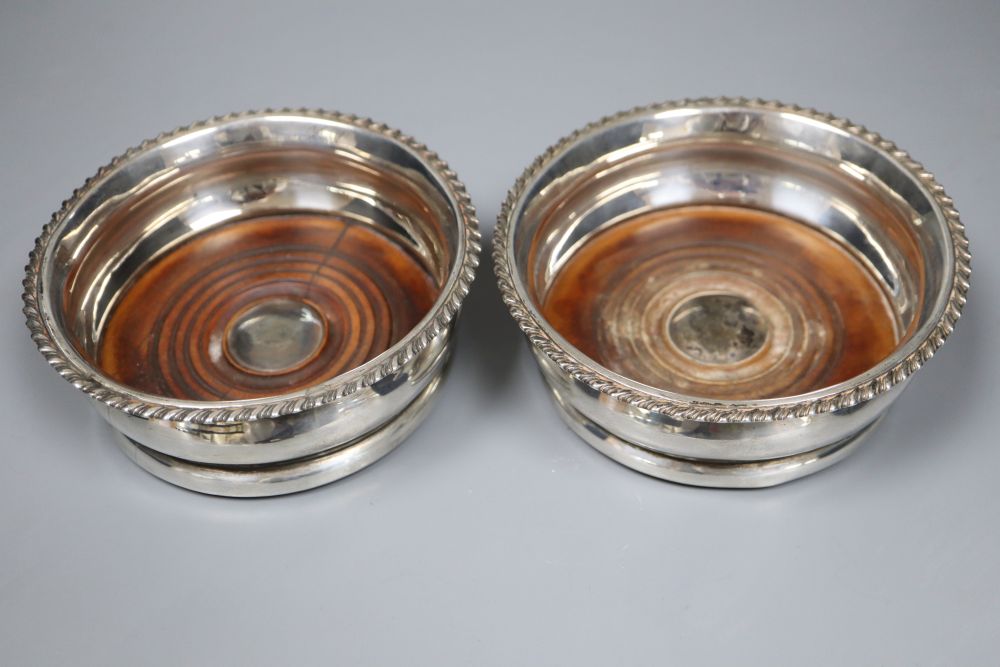 A pair of George IV silver wine coasters with tuned wooden bases, Adey Bellamy Savory, London, 1827, 13.3cm.